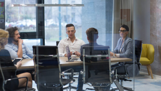 Group of a young business people discussing business plan at modern startup office building